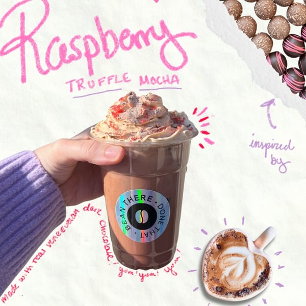 Hand holding a Bean There Done That Raspberry Truffle Mocha with whipped cream and sprinkles.